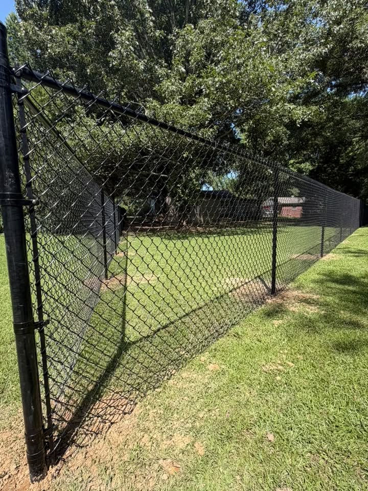Black chain-link fence installed by Integrity Fence & Outdoor around a grassy yard
