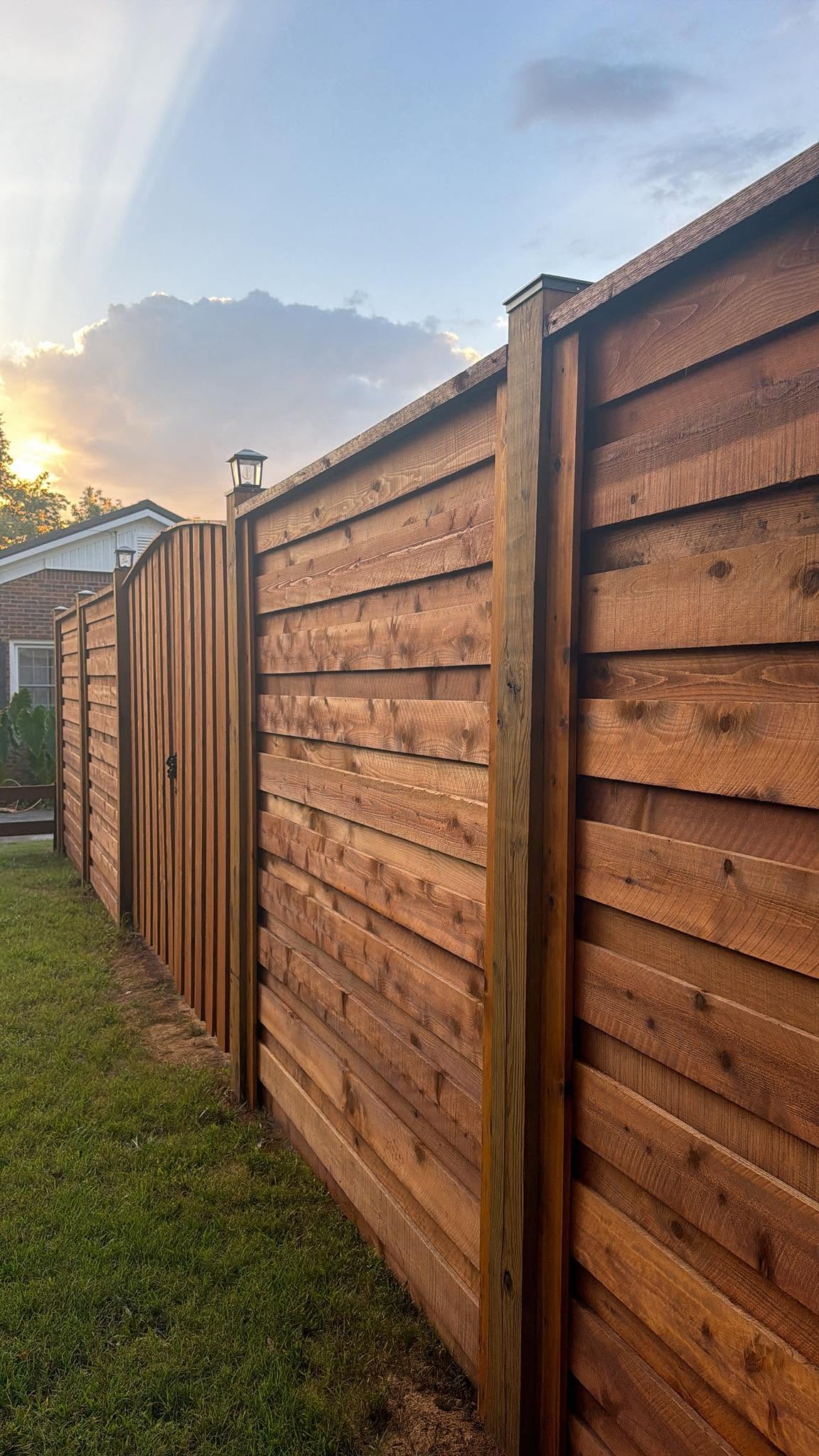 New stained wood privacy fence with capped posts built by Integrity Fence & Outdoor